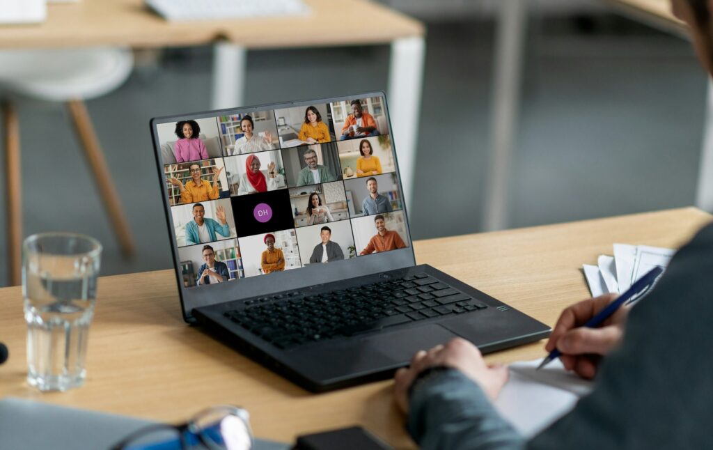 Person Attending Video Conference Meeting With Multiple Participants on Laptop